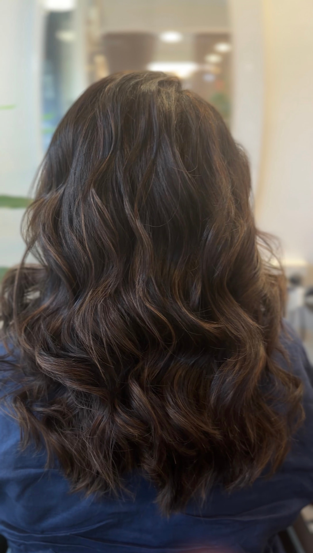 Glossy dark brunette waves with subtle warm lowlights