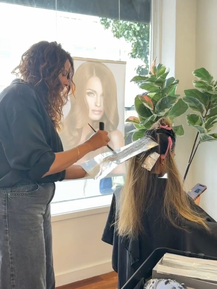 Shamalka hand painting foils for a client at Hair by Sha in Camberwell