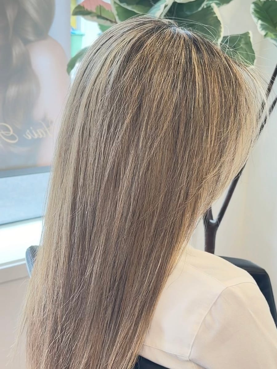 Long sleek blonde hair with soft dimensional highlights, finished in the studio